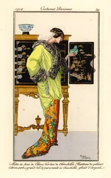 Nő selyemruhában, csincsilla szegéllyel, citromzöld bársonyköpeny csincsilla gallérral és mandzsettával, kezében jáde buddha. A háttérben kínai szekrény. Robe de soie de chine bordee de chinchilla, manteau de velours citron vert a grand col et parement.