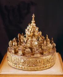 Mandala Tibetain: ritka darab sculppé arany bronzból. A mandala az isteni kozmosz képe, melynek közepén a Merou-hegy, a legfelsőbb isten, Indra palotája által körülvett hegy, amelyet négy kontinens vesz körül - Musée Guimet, Párizs
