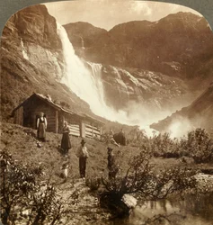 Szerény hegyi ház a sziklák lábánál, ahol a Skiaeggedals-vízesés 525 láb magasra ugrik, Norvégia, 1905.