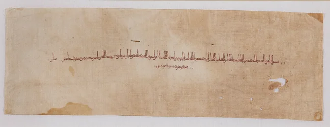 Textiltöredék tiráz sávval kufic írással, 900-901