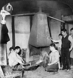 Egy japán kovács a kovácsműhelyében, Yokohama, Japán, 1904.