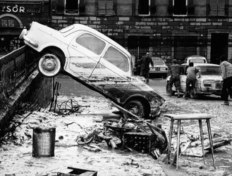 A Via dei Renai korlátján átdobott autó a firenzei árvíz idején, 1966 novemberében (fekete-fehér fotó)