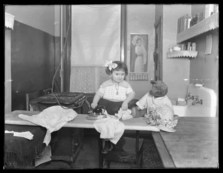 Azonosítatlan kislány elektromos vasaló használatát bemutató, 1913-14 körül