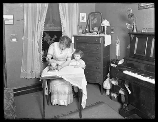 Azonosítatlan nő elektromos vasaló használatát bemutató, kislány nézte, 1913-14