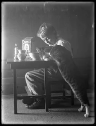 William Gray Hassler és Reddy, a macska, kvéker puffasztott rizspelyhet eszik, 1912 körül